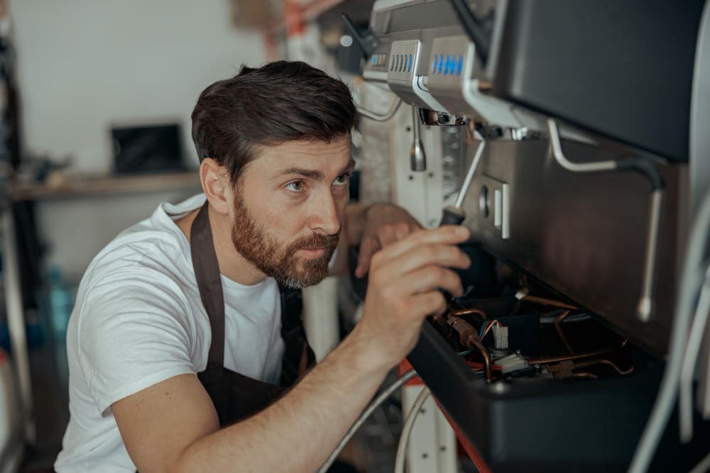 Repair specialist working on a commercial espresso machine.