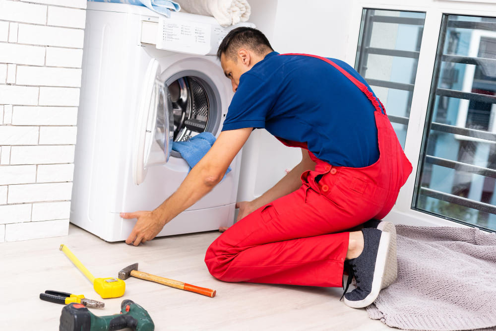 Repair technician checking a tumble dryer.