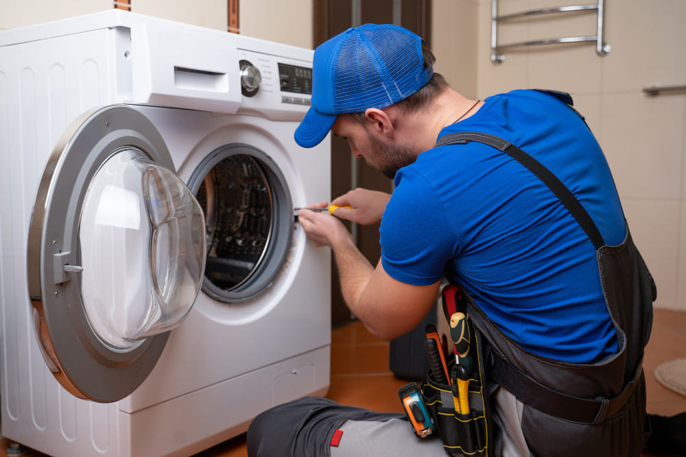 Technician examining a front-load washing machine.