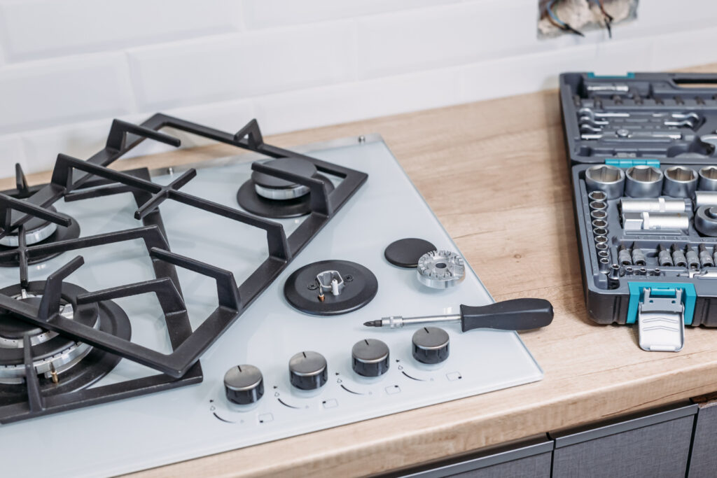 Technician checking gas stove burner ignition.
