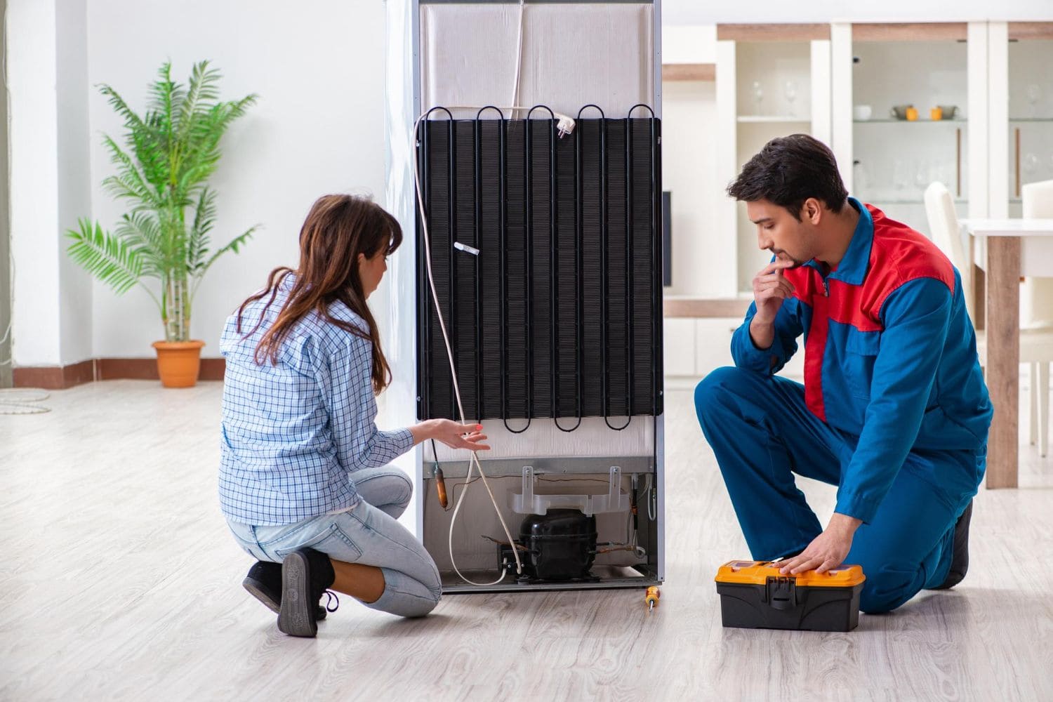 Technician repairing home appliance in a modern Dubai kitchen.